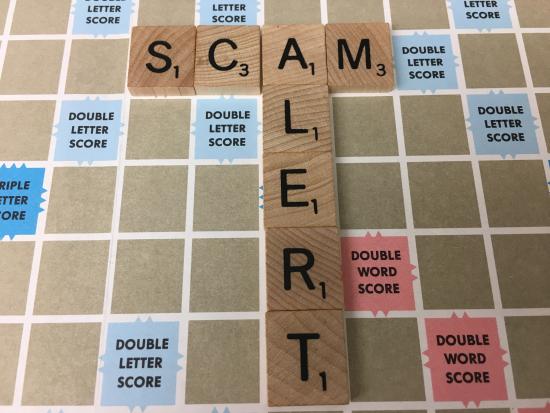 Scam alert image spelled out in Scrabble tiles